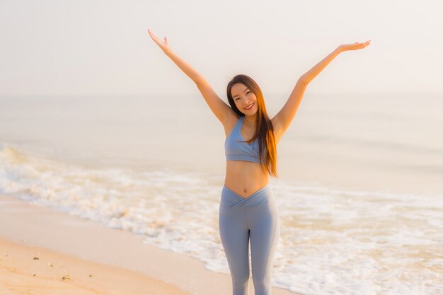 Женщина спорта портрета молодая азиатская подготавливает тренировку или бежит на океане моря пляжа