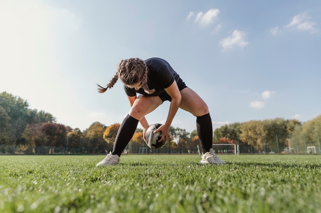 Portrait of sportive girl playing with a rugby ball