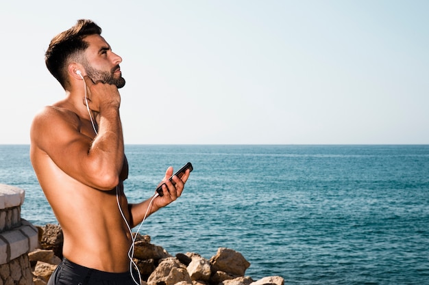 Free photo portrait of sportive man listening music