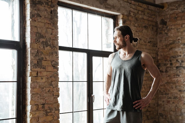 Free photo portrait of a sportsman resting while looking at the window