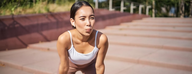 Free photo portrait of sportswoman panting taking break during jogging training sweating while running outdoors