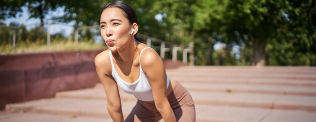 Free photo portrait of sportswoman panting taking break during jogging training sweating while running outdoors