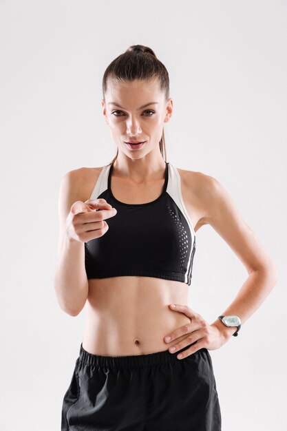 Portrait of a sportswoman standing and pointing finger