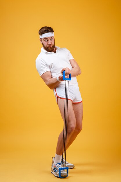 Portrait of a sporty man exercising with rubber expander