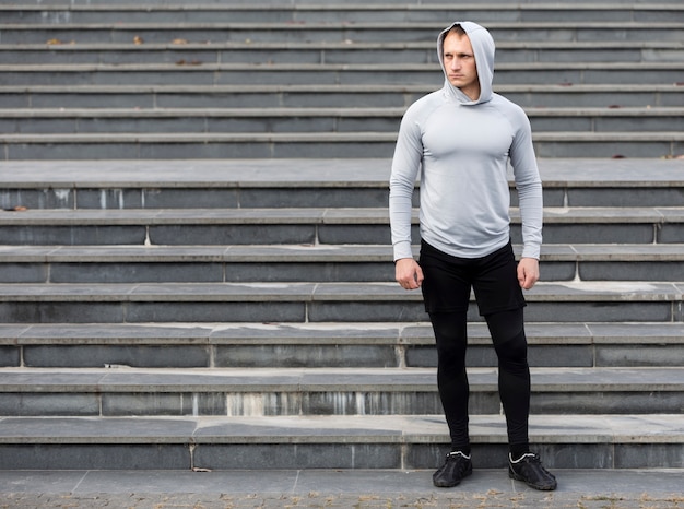 Portrait of sporty man in front of stairs