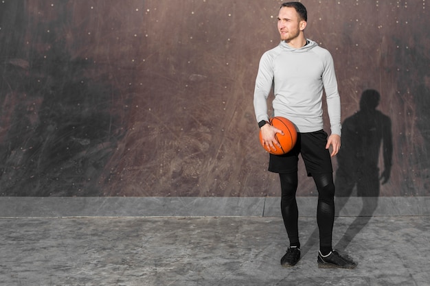 Foto gratuita ritratto di uomo sportivo con un pallone da basket