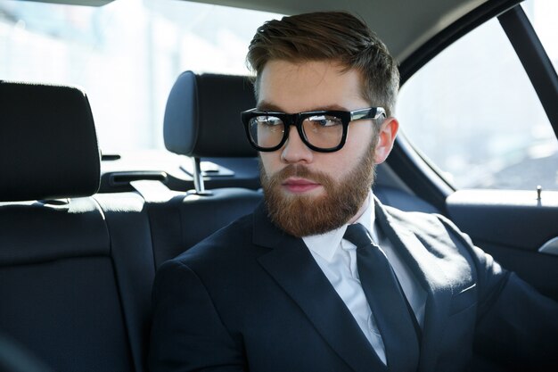 Portrait of a srious young man wearing suit and eyeglasses