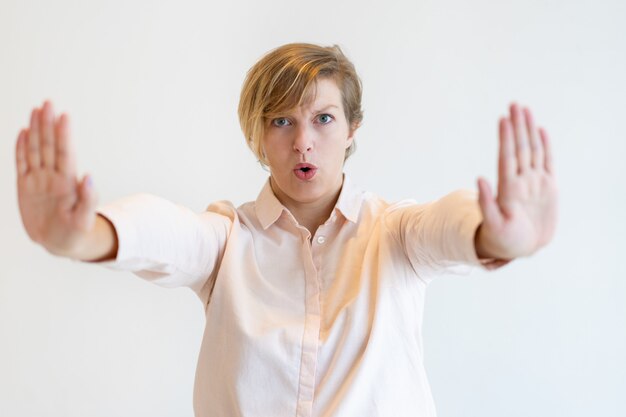 Portrait of stern mid adult businesswoman showing stop gesture