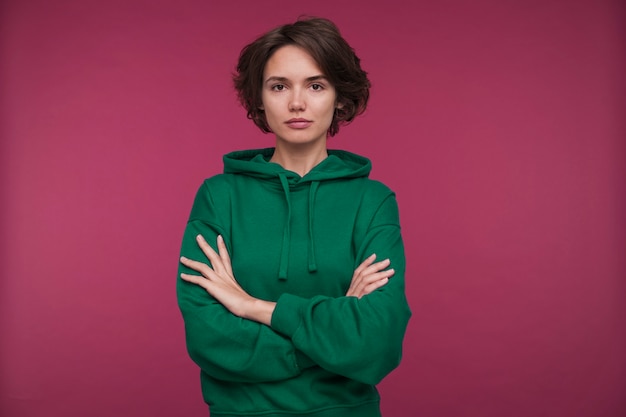 Free photo portrait of stoic young woman with crossed arms