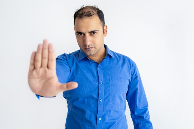 Portrait of strict mid adult businessman showing stop gesture