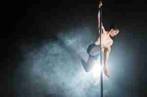 Free photo portrait of strong male model performing a pole dance