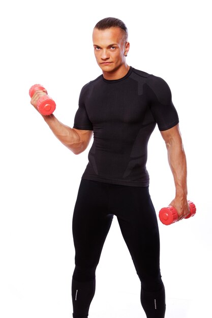 Portrait of strong man posing in studio with dumbbells