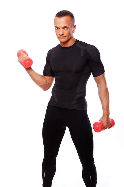 Portrait of strong man posing in studio with dumbbells