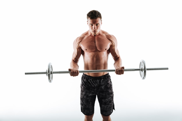 Portrait of strong sports man in black shorts exercising with barbell