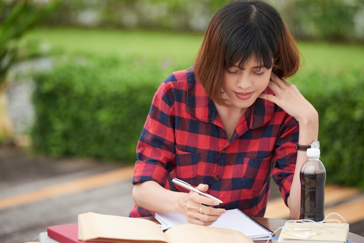 無料Photo キャンパスの屋外で宿題で忙しい学生の肖像画