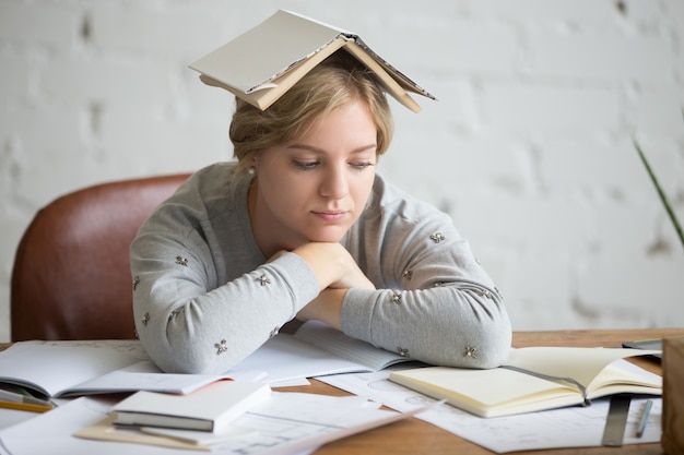 Foto gratuita ritratto di ragazza studente con libro aperto sulla sua testa