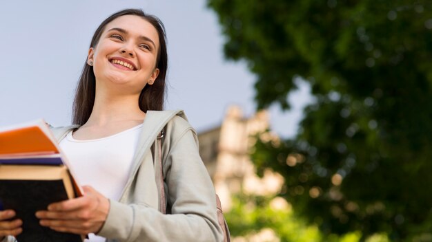 Portrait of student holding books at campus