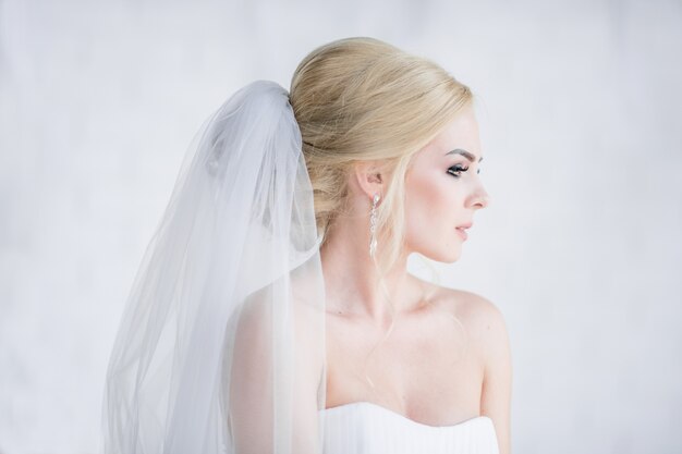 Портрет потрясающей блондинки невесты в платье с обнаженными плечами