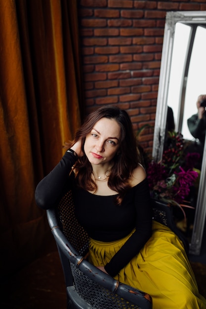 Free photo portrait of a stunning fashionable woman sitting in a chair