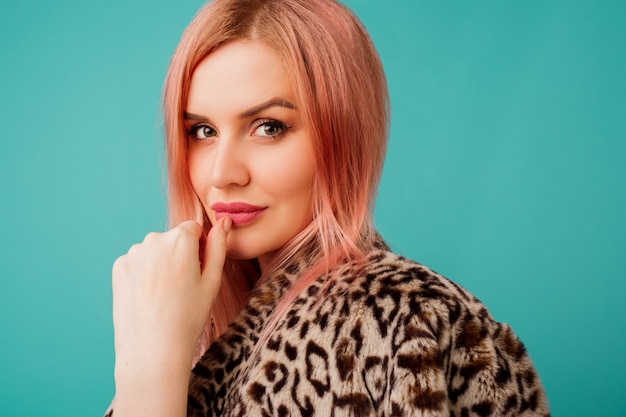 Portrait of stunning woman with pink hair in stylish winter fluffy coat with leopard print