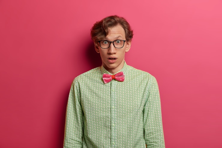 Free Photo portrait of stupefied shocked young male teacher stares through transparent glasses, dressed formally, embarrassed to get unexpected task for project, expresses wonder and disbelief, poses indoor