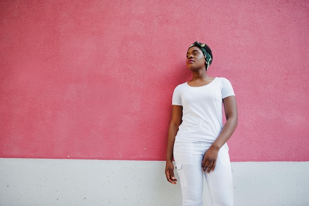 Free photo portrait of stylish african american girl wear on white clothes against pink wall street fashion of young black people
