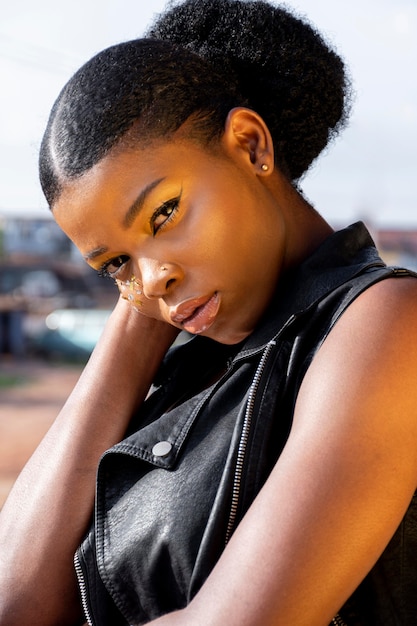 Portrait of stylish african woman in leather vest outdoors