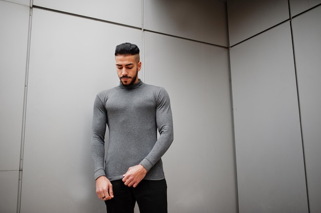 Portrait of stylish arab beard man wear grey turtleneck Arabian model guy against steel wall