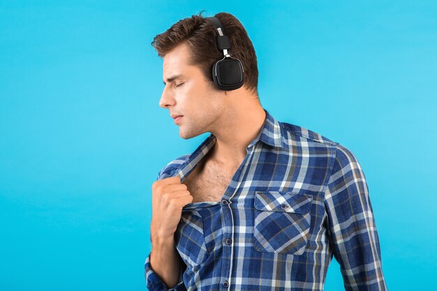 Portrait of stylish attractive handsome young man listening to music on wireless headphones having fun modern style happy emotional mood 