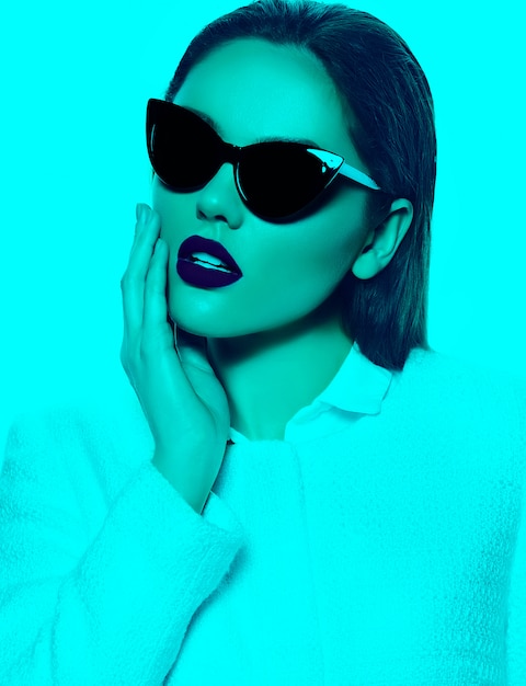 Portrait of stylish beautiful young woman with sunglasses in turquoise