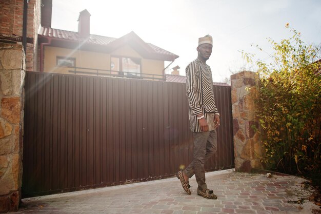 Portrait of stylish black african american man at hat and sunglasses against fence