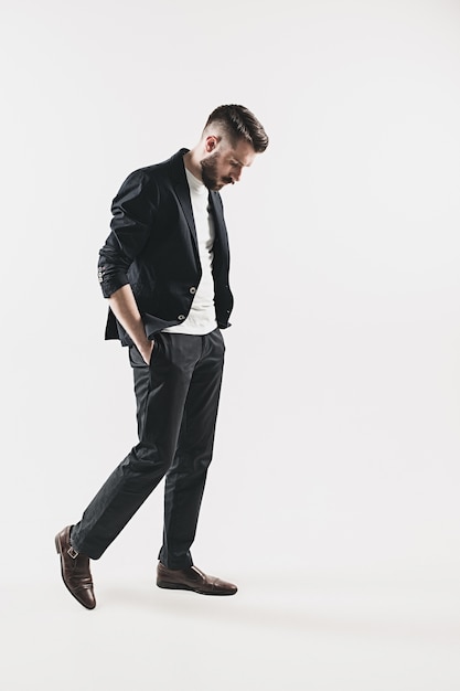 Portrait of stylish handsome young man standing against white. Man wearing jacket