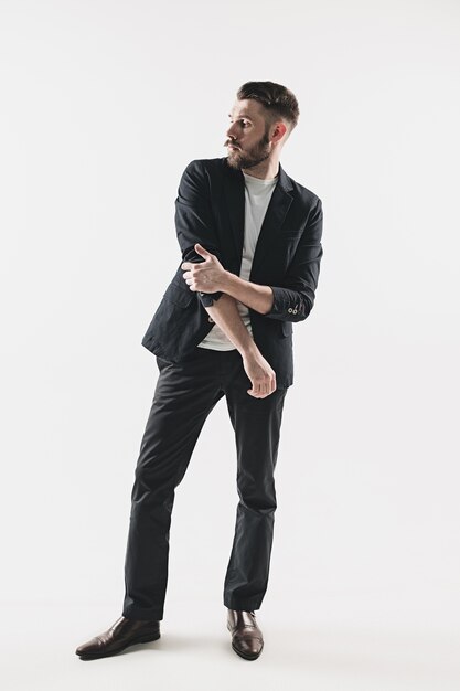 Portrait of stylish handsome young man standing against white. Man wearing jacket