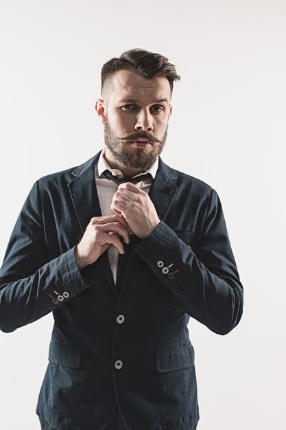 Portrait of stylish handsome young man standing against white. Man wearing jacket