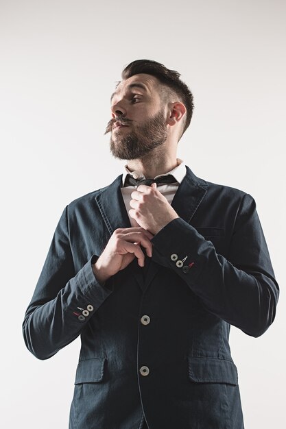 Portrait of stylish handsome young man standing at studio against white. Man wearing jacket