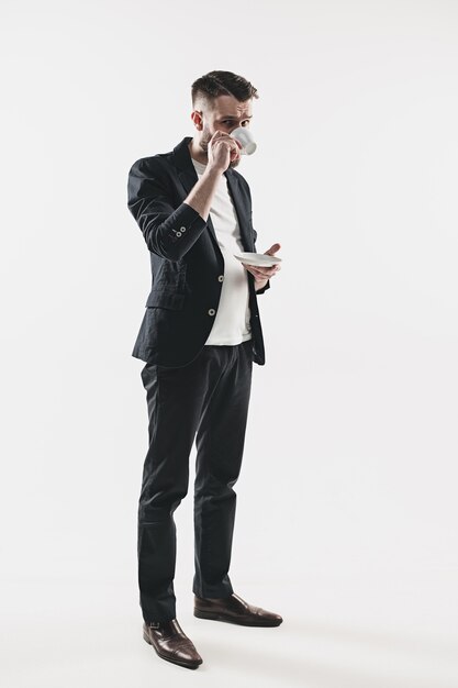 Portrait of stylish handsome young man standing at studio.