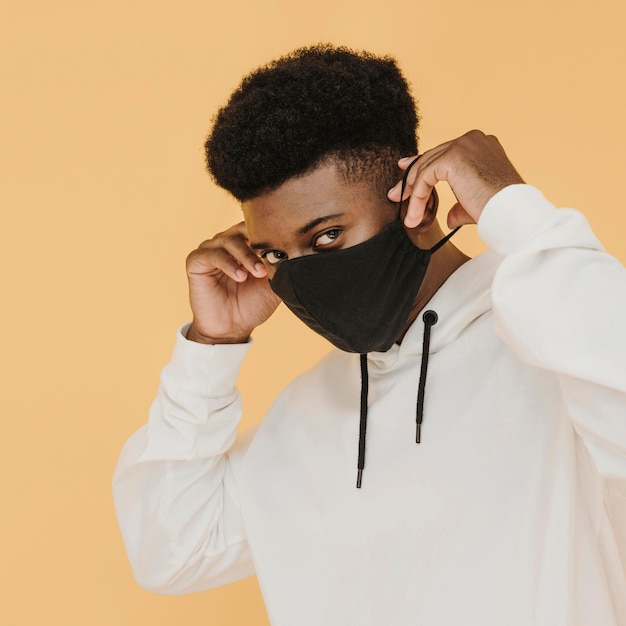 Free photo portrait of stylish man putting on face mask