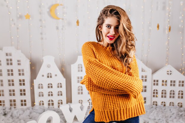 Portrait of stylish, mysterious girl of 23 years old in mustard warm sweater. woman with long hair posing