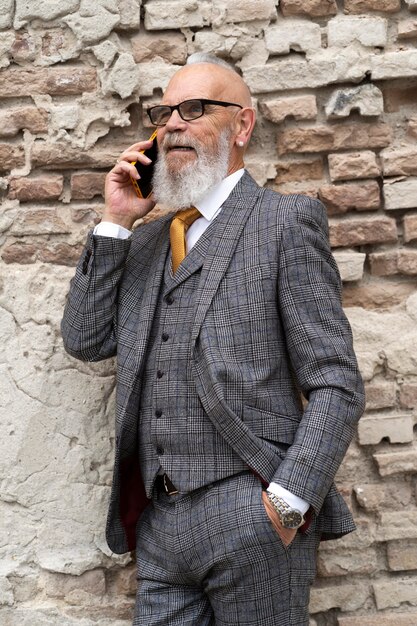 Портрет стильного старшего мужчины на своем телефоне