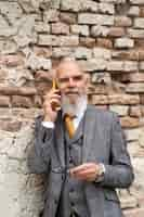 Free photo portrait of stylish senior man on his phone