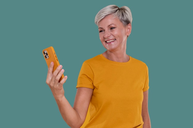 Free photo portrait of stylish senior woman holding her phone