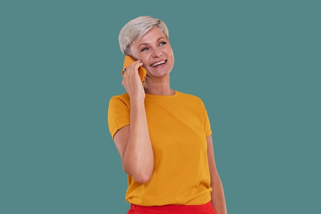 Ritratto di donna anziana alla moda che parla al telefono