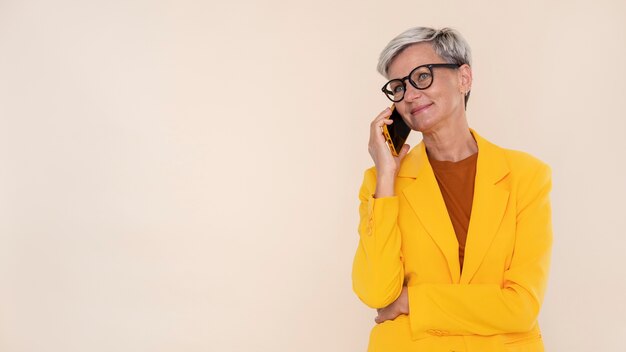 Портрет стильной старшей женщины разговаривает по телефону