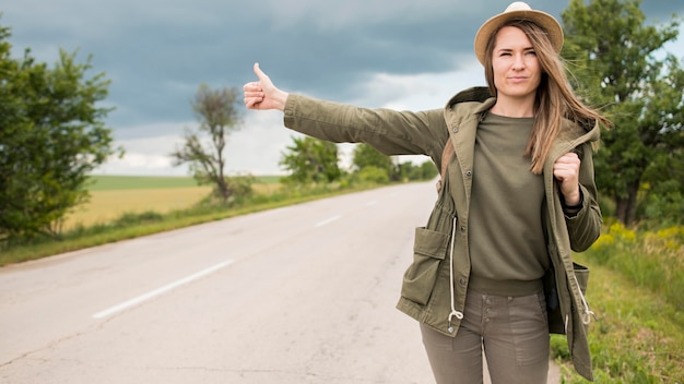 Free photo portrait of stylish traveller hitchhiking