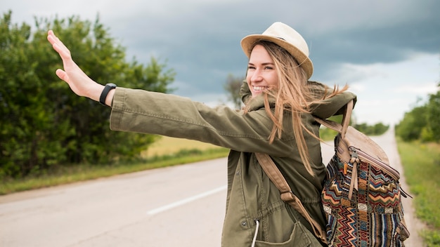 Portrait of stylish traveller hitchhiking