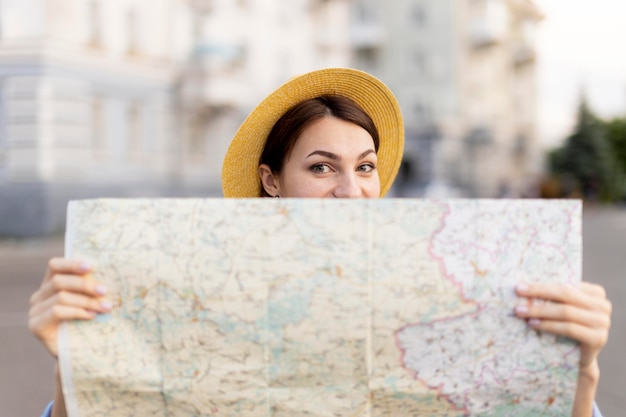 Free photo portrait of stylish traveller with hat holding map