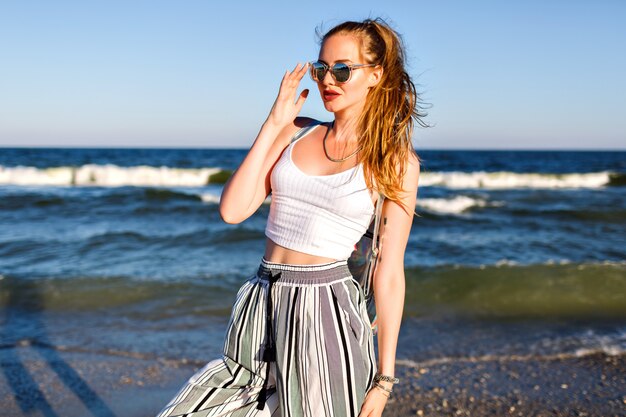 Portrait of stylish woman posing, summer crop top sunglasses and culottes