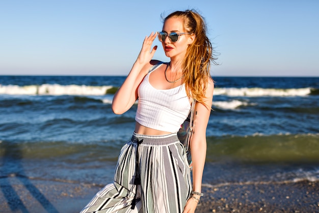 Portrait of stylish woman posing, summer crop top sunglasses and culottes