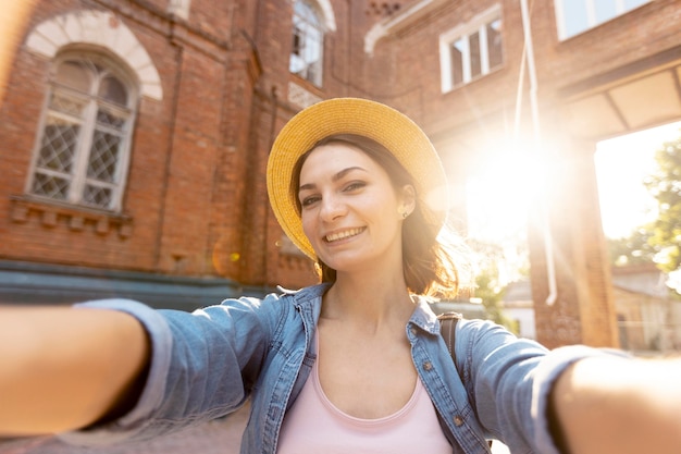 Foto gratuita ritratto di donna elegante con cappello prendendo un selfie