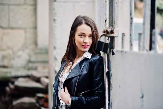 Portrait of stylish young girl wear on leather jacket and ripped jeans at streets of city Street fashion model style